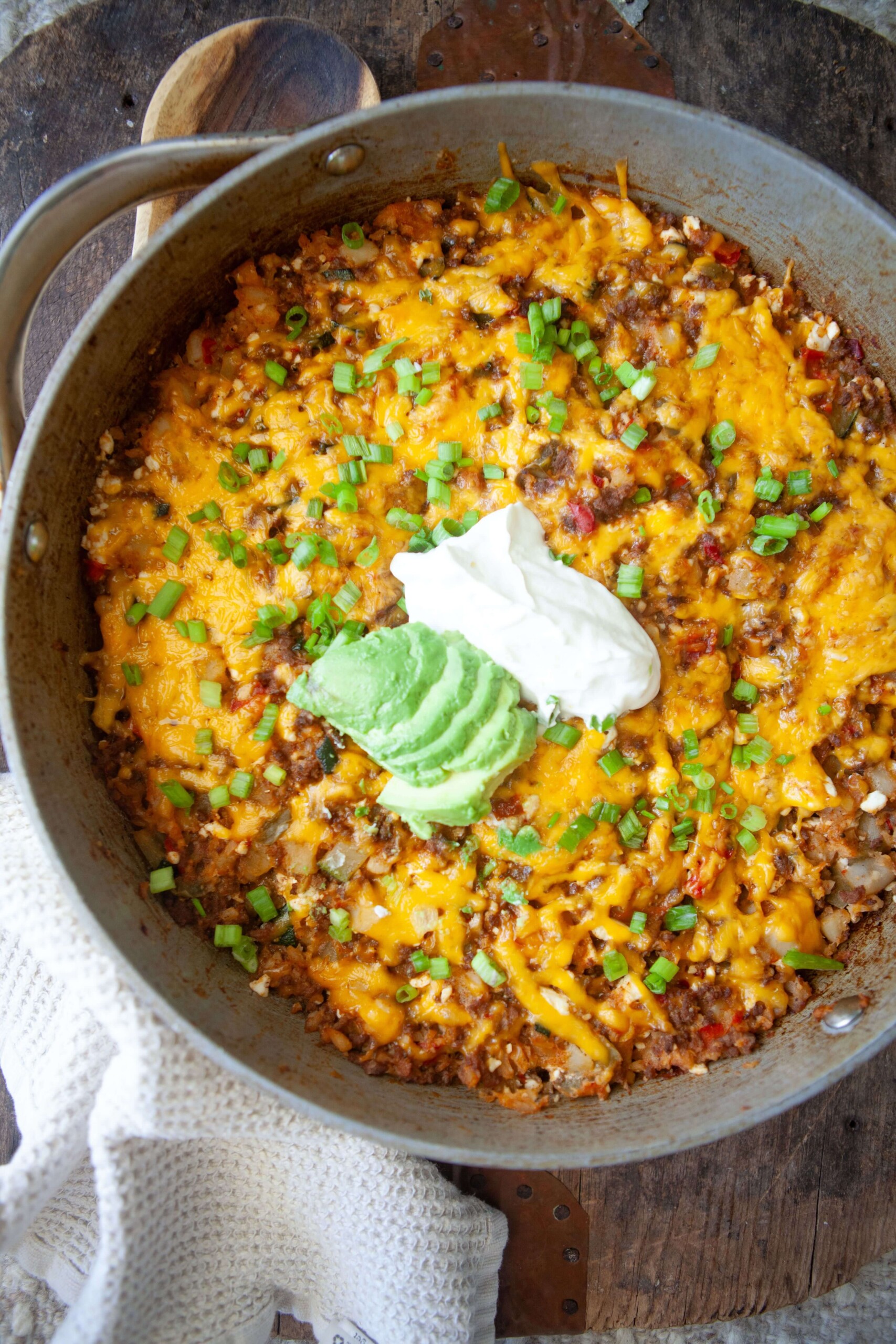 Skillet mexican potatoes cooked in a large skillet and topped with sour cream and avocado.