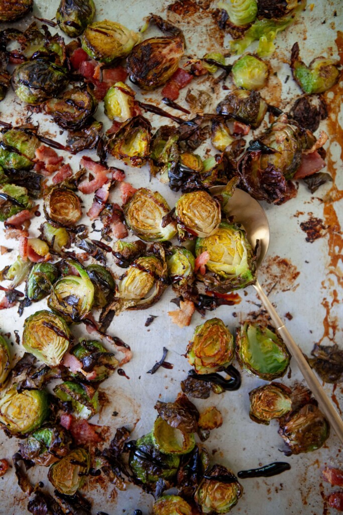 Roasted brussels sprouts on pan drizzled with balsamic glaze.
