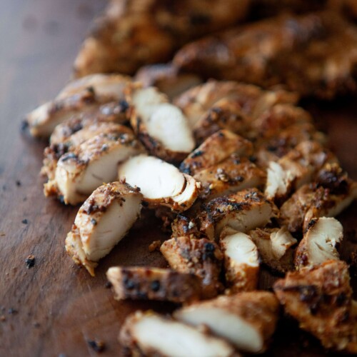 Balsamic, dijon, garlic chicken tenders cut on wooden cutting board.