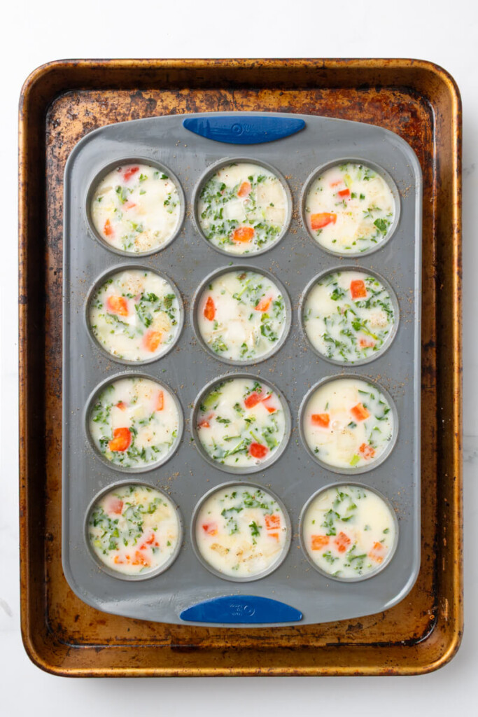 Egg white cups poured into silicone mold on baking tray with water bath.