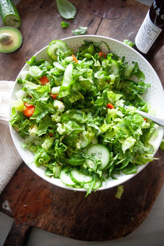 House salad tossed together and served in large white bowl.
