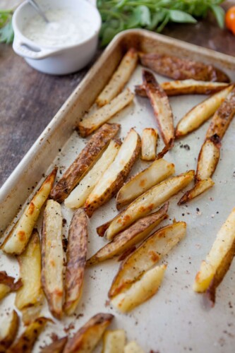Thick cut oven roasted fries on baking sheet.