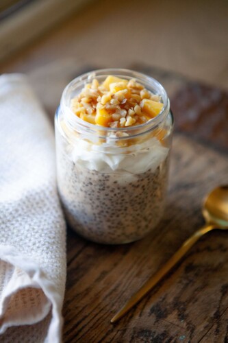 Overnight oats made in a jar and topped with fresh mango and walnut.