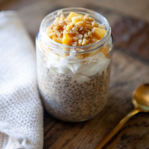 Overnight oats made in a jar and topped with fresh mango and walnut.