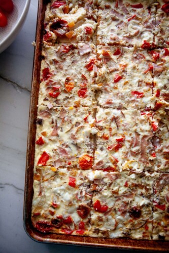 Sheet pan roasted veggie egg bake cooked and sliced on large sheet pan.