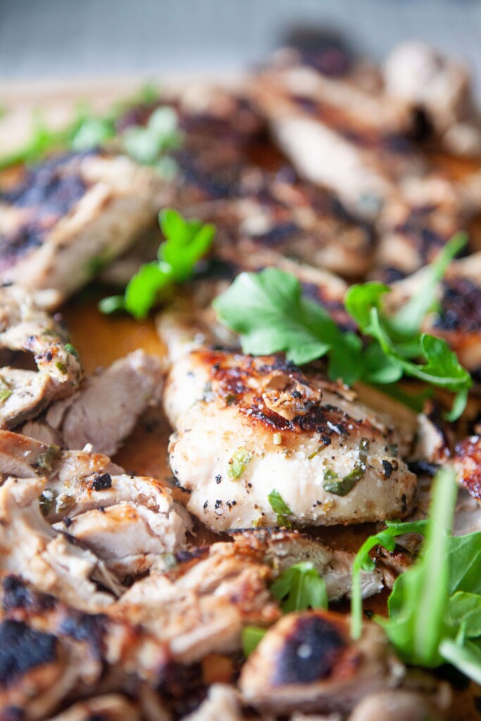 Honey chipotle chicken thighs on cutting board topped with fresh cilantro.