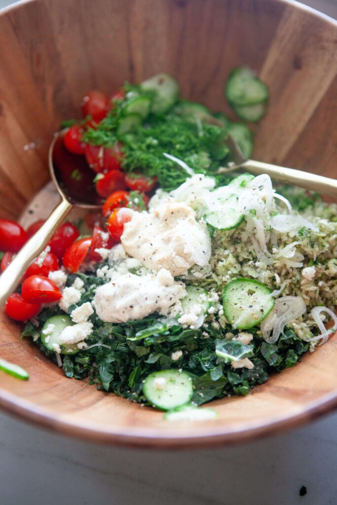Ingredients for kale and lentil salad added to salad bowl before mixing.