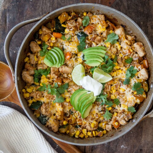 Zucchini, corn and chicken skillet topped with toppings in skillet.