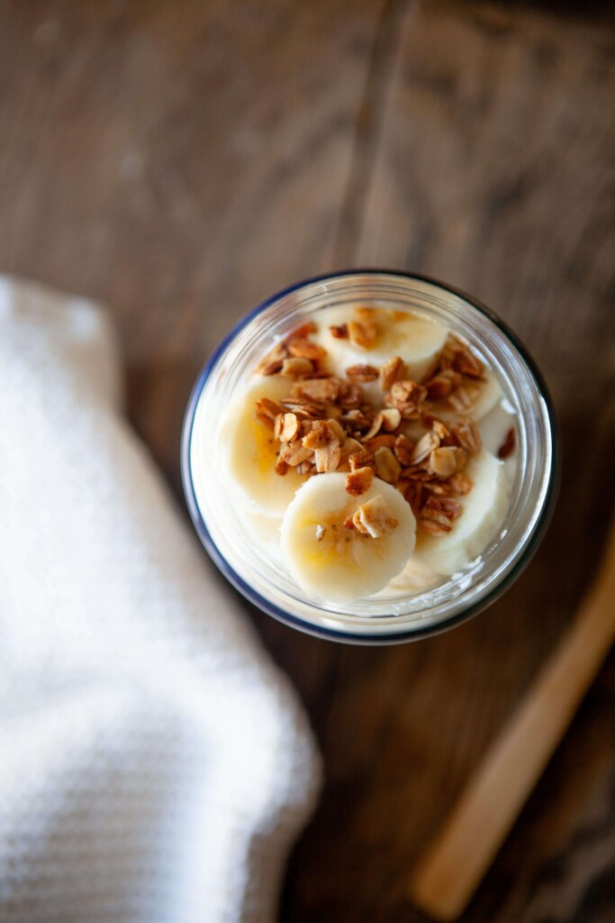 Banana and granola sprinkled on top of banana pudding overnight oats.