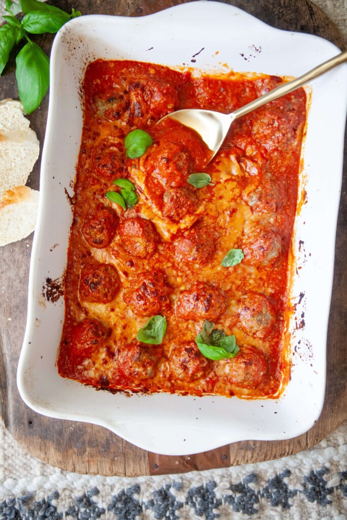 Cottage cheese meatballs cooked in pan and garnished with fresh basil.