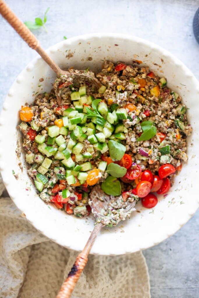 All the ingredients for lentil salmon salad in large white bowl.