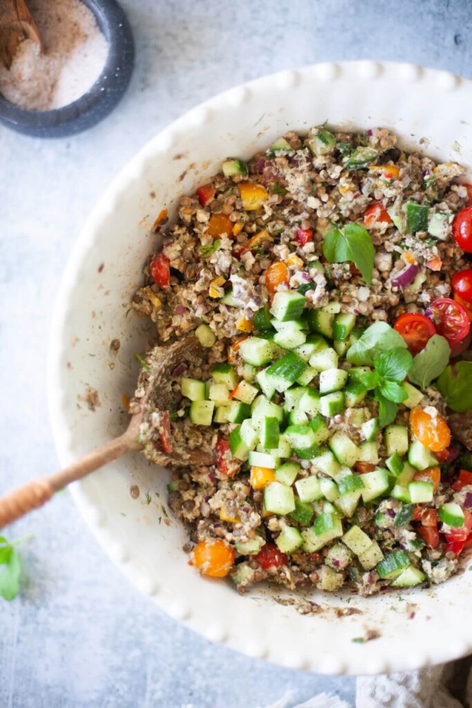 Ingredients for lentil salmon salt tossed together in large serving bowl.