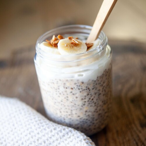 Chia oats in a jar with toppings and a spoon.