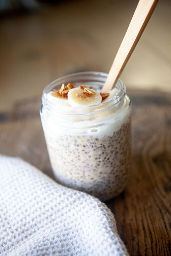 Chia oats in a jar with toppings and a spoon.