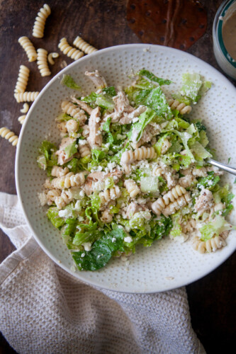 Caesar pasta salad in a white bowl.