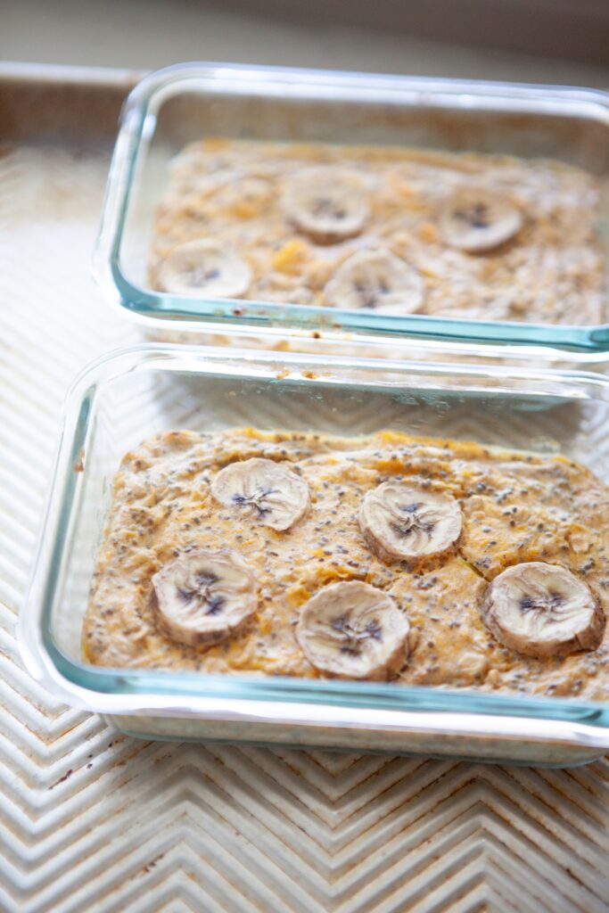 Baked butternut squash oats with banana coins and chia seeds in glass meal prep containers