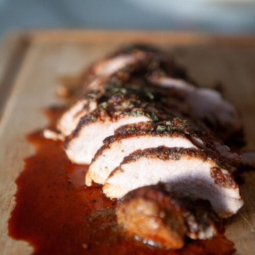 Close-up of juicy sliced BBQ pork tenderloin showing the tender center and seasoned crust