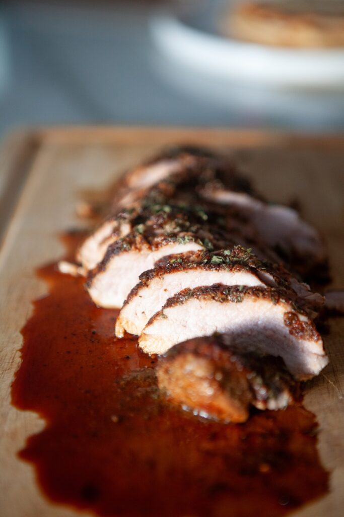 Close-up of juicy sliced BBQ pork tenderloin showing the tender center and seasoned crust